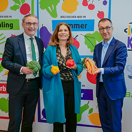 Offizielle Gäste mit Gemüse vor der Ich-kann-kochen-Fotowand beim BARMER Presse-Event
